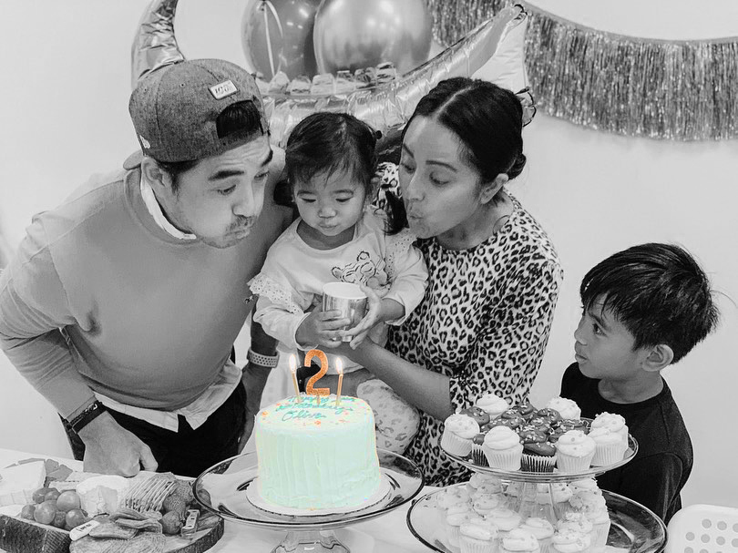 Family blowing out candles on Celebration Cake