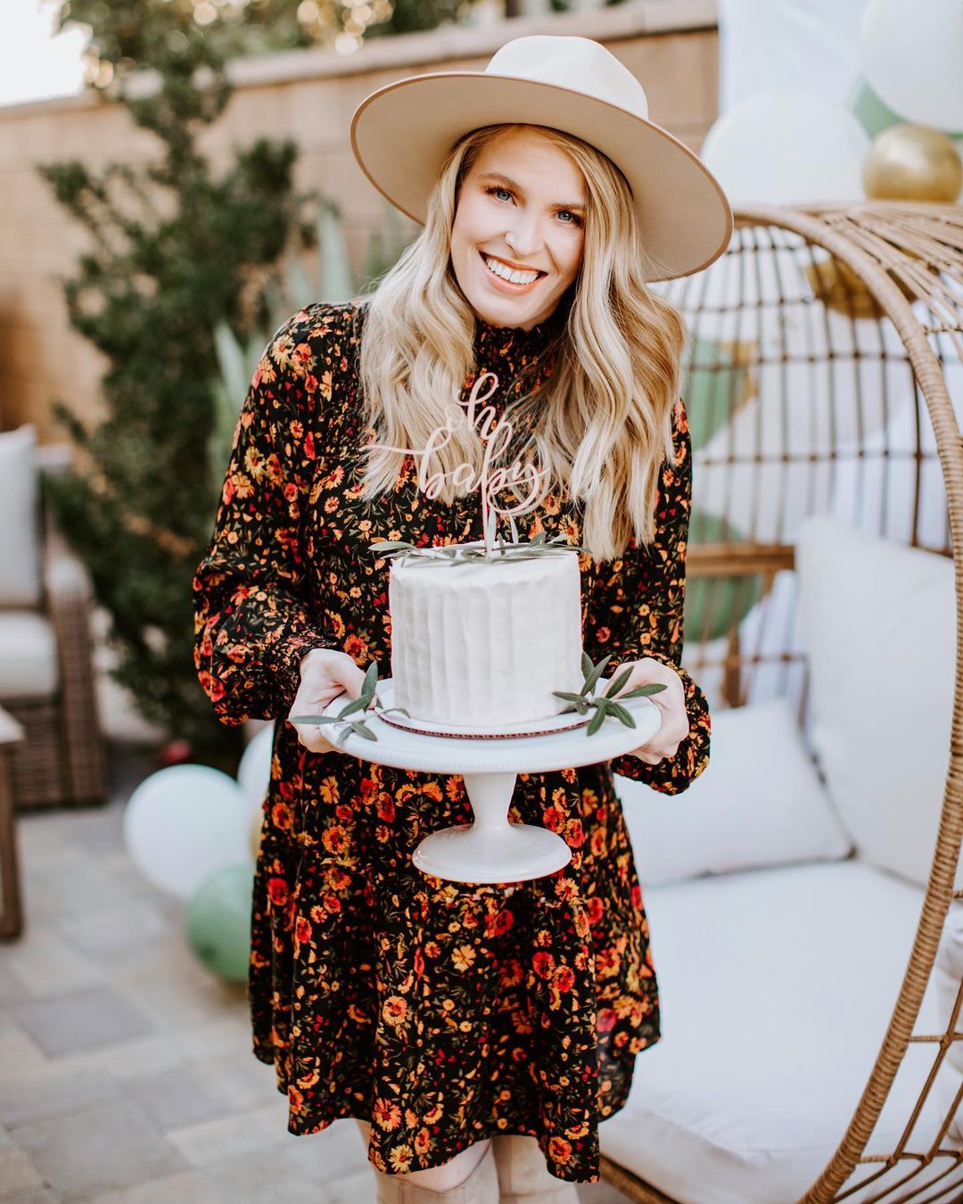 Pregnant Guest holding a cake that says Oh Baby 