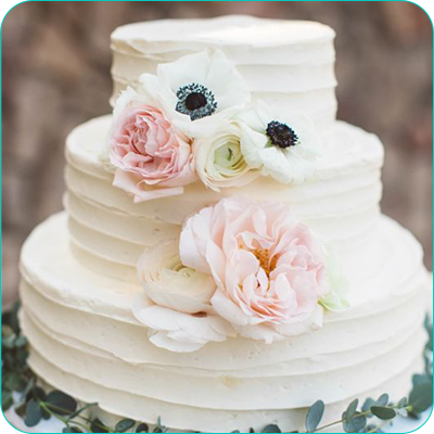 Three tier white wedding cake with flowers